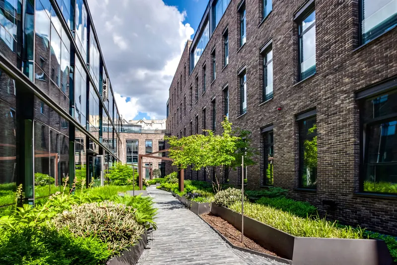 Artisan, planted courtyard between brick buildings
