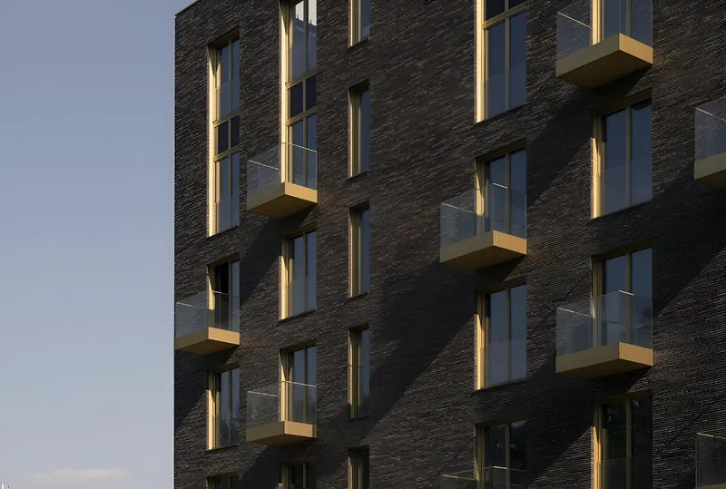Tessinsky 1, dark brick facade with brass balconies